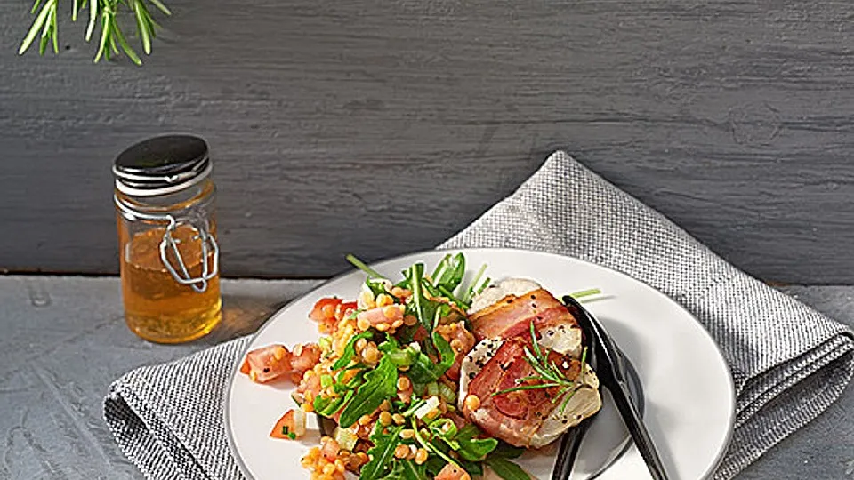 Ziegenkäse im Speckmantel auf buntem Linsensalat